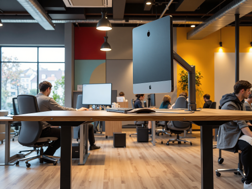 现代化办公环境,宽敞明亮的办公室内有多名员工正在工作,使用多台电脑和显示器,墙上挂着公司标识,展现专业科技公司的工作氛围